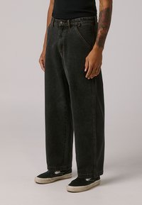 Black denim wide-leg pants with a high waist, featuring classic five-pocket design, subtle stitching, and a relaxed fit.