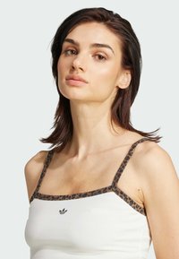 White tank top with leopard print straps, featuring a square neckline and an embroidered logo at the center. Smooth fabric texture.