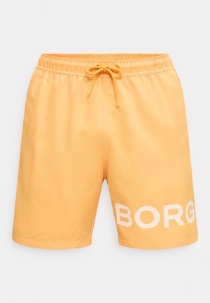 Oranžové plavky so sťahovacím pásom a šnúrkou, s veľkým bielym nápisom "BORG" na ľavej nohe.