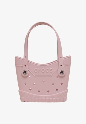 Light pink Crocs tote bag with perforated holes, two shoulder straps, and Crocs logo embossed on the front.