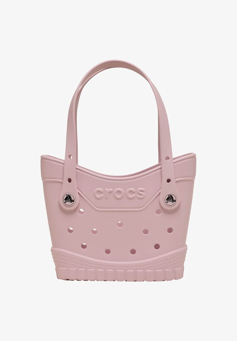 Lichtroze Crocs draagtas met geperforeerde gaatjes, twee schouderbanden en het Crocs-logo aangebracht op de voorkant.