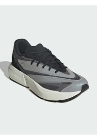 Sportowe sneakersy z czarno-szarym siateczkowym wnętrzem, teksturowanymi wstawkami, wyraźnym wzorem podeszwy oraz sznurowaniem przez wyściełany język.