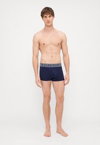 Pánské boxerky v námořnické modři s elastickým páskem s logem. Vyrobené z měkké látky, mají těsný střih a krátkou délku nohaviček.