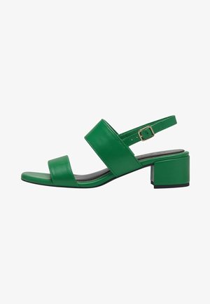 Green leather sandal featuring a block heel, two wide straps across the foot, and an adjustable ankle strap. Smooth texture and minimalist design.