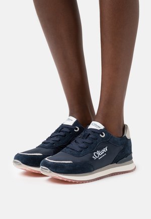 Navy blue sneakers with suede and synthetic mesh, featuring white accents, a padded collar, and a textured rubber sole. Logo displayed.