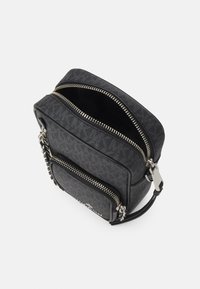 Borsa nera con esterno testurizzato, doppia cerniera, tasca frontale, accessori in argento e tracolla regolabile. Presenta un design minimalista.