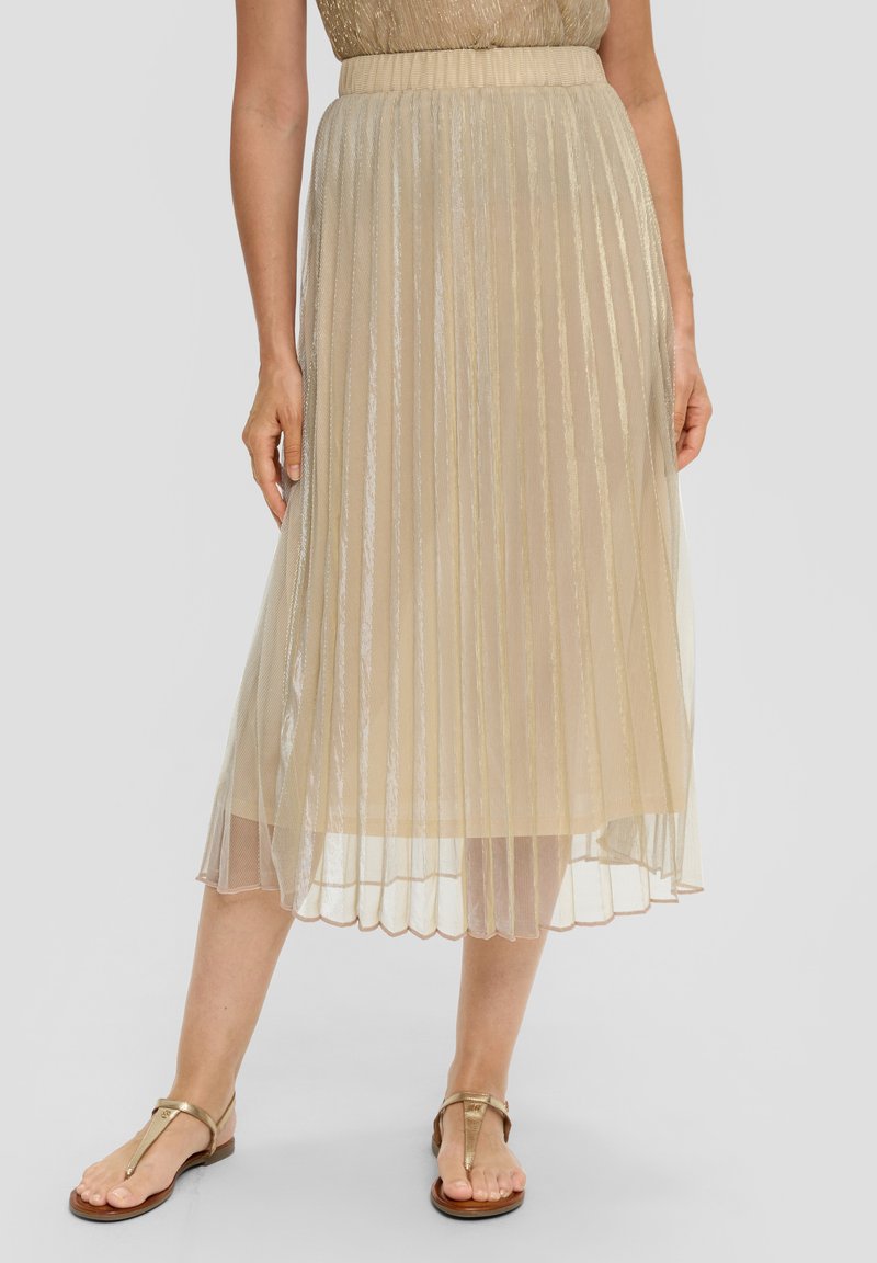 Jupe midi plissée en tissu doré transparent avec une apparence texturée. Dotée d'une taille solide et d'un ourlet festonné. Associée à des sandales dorées.