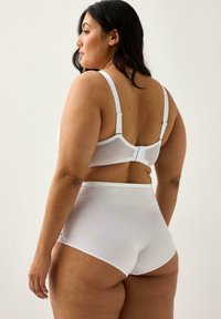 Hvid bh og sæt med højtaljede trusser. Blødt stof med en glat overflade. Justerbare stropper og hægte- og øje-lukning på bh'en.
