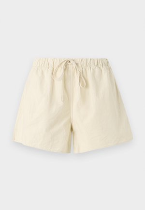 Beige elastic waistband shorts with a drawstring tie, featuring a relaxed fit and smooth texture. No visible pockets or patterns.