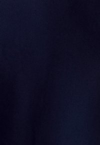 Tummansininen kangas, jossa on sileä pinta ja hienovarainen kiilto, esittää tasaisen kiinteän värin ilman kuvioita tai yksityiskohtia.