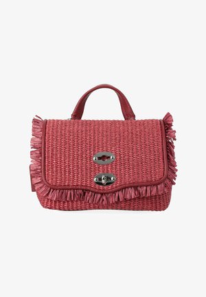 Sac à main tissé rouge avec une petite poignée, garniture à franges autour des bords et deux fermoirs en métal argenté sur le rabat avant.