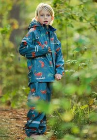 Vandtæt sæt med regnjakke og bukser til børn i teal, med et dyreprint, elastiske manchetter og reflekterende striber for synlighed.