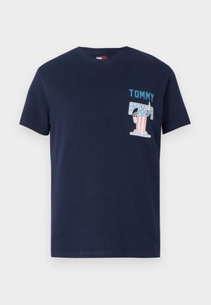Marineblå bomull t-skjorte med rund hals. Har "TOMMY" i teal og et grafikk av en "T" med stjerner og striper. Korte ermer.