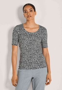 Kurzarmoberteil im schwarz-weißen Leopardenmuster mit Rundhalsausschnitt und figurbetonter Silhouette, aus leichtem, glattem Material gefertigt.