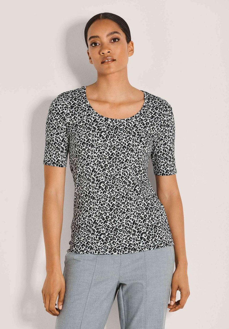 Kurzarmoberteil im schwarz-weißen Leopardenmuster mit Rundhalsausschnitt und figurbetonter Silhouette, aus leichtem, glattem Material gefertigt.