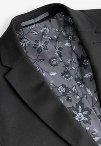Black blazer with a floral-patterned grey lining, featuring a classic design, smooth texture, and notched lapel details.