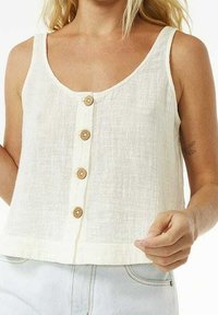 Débardeur en lin blanc avec un encolure dégagée, présentant une patte de boutonnage centrale avec des boutons en bois et une coupe ample et courte.