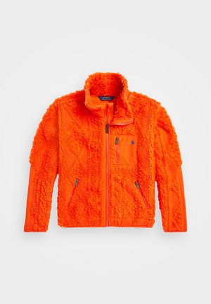 Casaco de polar em laranja brilhante, com uma superfície texturizada, gola alta e bolsos com fecho éclair. Apresenta um bolso no peito com um logo.