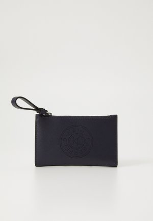Navy leather wallet with a smooth texture, featuring a perforated circular logo, zip closure, and a wrist strap. Compact rectangular shape.