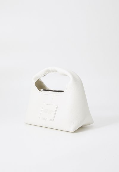 Sac à main en cuir blanc avec une forme triangulaire structurée, une poignée arrondie et une fermeture éclair. Présente une surface texturée et un patch logo.