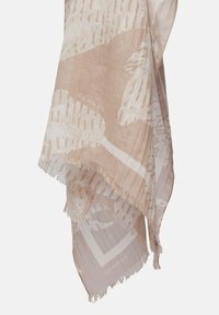 Lekki, beżowy szalik z abstrakcyjnymi białymi wzorami, frędzlami po brzegach i subtelną teksturą. Materiał jest miękki i półprzezroczysty.