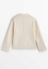 Beige stickad cardigan med hög krage, ribbade ärmslut och fåll. Har en mitt bak söm för designens skull. Mjuk textur och avslappnad passform.