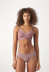 Soutien-gorge sans fil mauve avec décolleté en V, rembourrage léger et bretelles ajustables. Associé à une culotte taille basse assortie. Texture de tissu lisse.