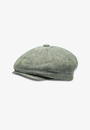 Green linen flat cap with a rounded shape, buttoned top, and a wide curved brim. Textured fabric with subtle stitching details.