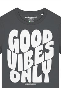 Grijze katoenen t-shirt met ronde halslijn, featuring vette witte tekst die zegt "GOOD VIBES ONLY" en "SAYS WATAPPAREL" daaronder.