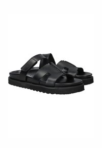 Zwarte leren sandalen hebben meerdere brede banden en een dikke zool met een gestructureerd profiel voor betere grip.