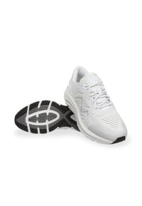 Zapatillas deportivas blancas con una parte superior texturizada, puntera reforzada y suelas de goma negras y grises coordinadas que presentan un patrón de banda de rodadura.