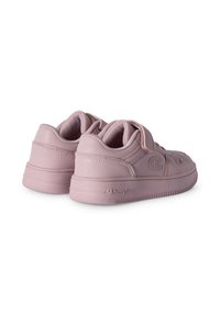 Un par de zapatillas de lona rosa pastel de corte bajo con correas de velcro y logotipos de Champion en los lados y suelas, mostradas desde los ángulos trasero y lateral.