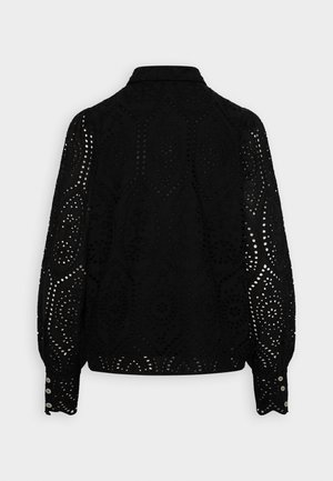 Black blouse featuring intricate cut-out patterns, long sleeves, and button cuffs. The design includes rounded collar and textured finish.