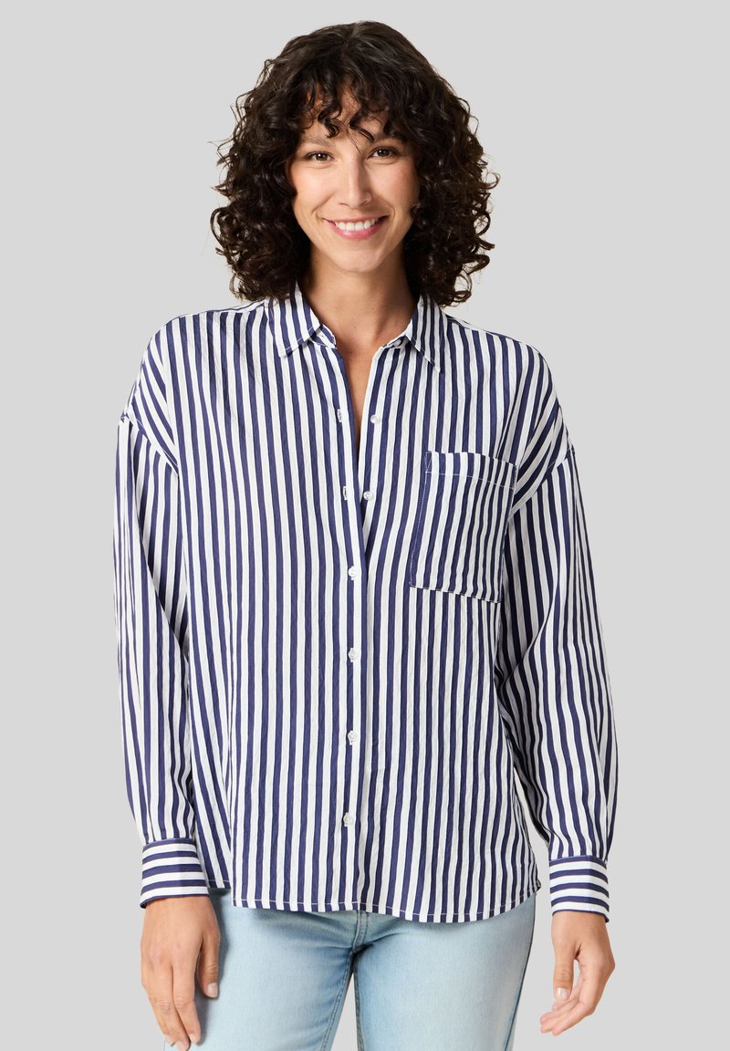 Camicia a righe blu navy e bianca con maniche lunghe, taschino frontale e vestibilità comoda. Realizzata in tessuto leggero con una texture liscia.