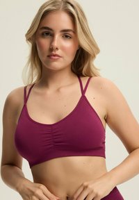 Burgundowy prążkowany braletka z cienkimi ramiączkami i marszczonym wykończeniem na środku, miękka tkanina, dopasowany krój i minimalistyczny kształt.