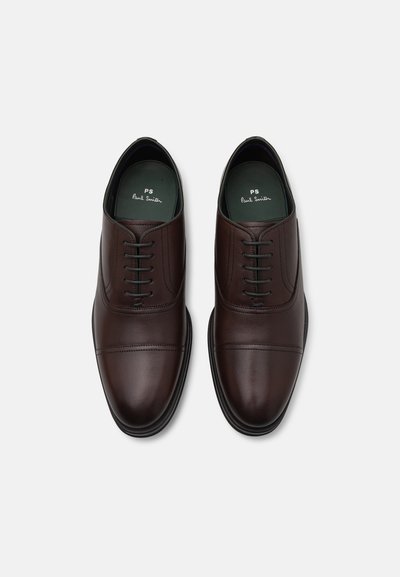 Scarpe eleganti in pelle marrone con una finitura liscia, design con lacci e dettagli di cucitura sottili. Presentano una suola piatta e una soletta con marchio.