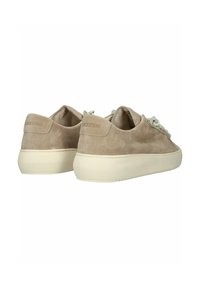 Beige Wildledersneaker mit strukturiertem Finish, Schnürdesign und einer weißen Gummisohle mit Branding an der Ferse.