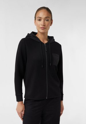 Felpa nera con zip, cappuccio regolabile, tasca frontale e polsini a costine. Tessuto morbido, design minimalista e silhouette aderente.