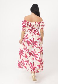 Robe maxi à imprimé floral avec des motifs roses et beiges, décolleté élastiqué à épaules dénudées, corsage smocké et jupe fluide.
