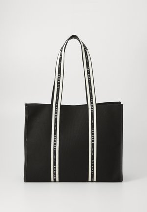 Bolso tote negro con tejido texturizado, que presenta dos asas robustas a rayas negras y blancas. Nombre de la marca impreso a lo largo de las correas. Diseño rectangular.