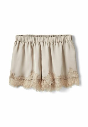 Béžové saténové šortky s elastickým pásom a vlnkovanou čipkovou ozdobou pozdĺž okraja, zobrazené na bielom pozadí.