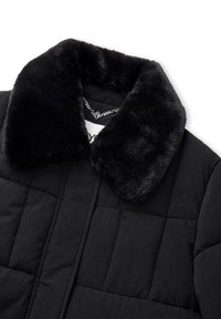 Zwarte gewatteerde jas met een plush nepbont kraag. De stof is glad met een matte afwerking, waardoor de textuur en de details van de naden zichtbaar zijn.