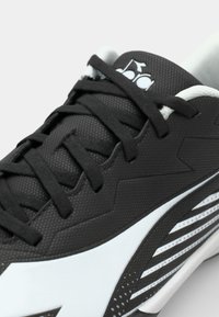 Sort atletisk sneakers med tekstureret overdel, prydet med hvide accenter og vinklet design. Snørebåndene er sorte, med et distinkt logo på tungen.