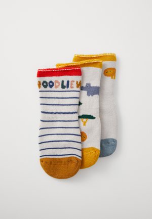 Three pairs of cotton socks: red and white striped, gray with patterned accents, and bright yellow with a solid toe. Various playful designs.