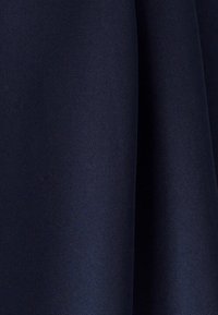 Mornarsko modro tekstilijo s gladko, mat teksturo in subtilnim vzorcem tkanja, ki tvori nežne gube v tkanini.