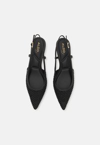 Sorte slingback hæle med spidse tæer og tekstureret overdel med perle-lignende udsmykninger. Glat indvendig foring og justerbar rem.
