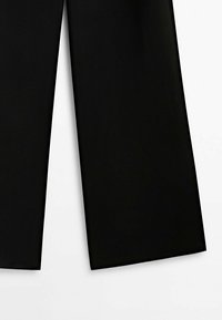 Pantalon noir à jambes larges, visible du milieu de la cuisse à l’ourlet sur fond blanc.