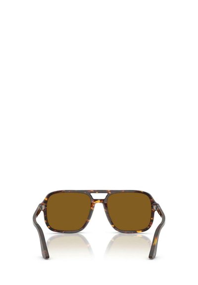 Gafas de sol de montura cuadrada con un patrón de carey, lentes marrones y finos acentos de metal a los lados. Presentan un diseño de recorte único.