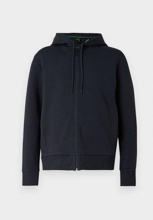 Tmavomodrá mikina na zips z jemnej látky, vybavená kapucňou so sťahovacou šnúrkou, rebrovanými manžetami a nenápadným logom na hrudi.