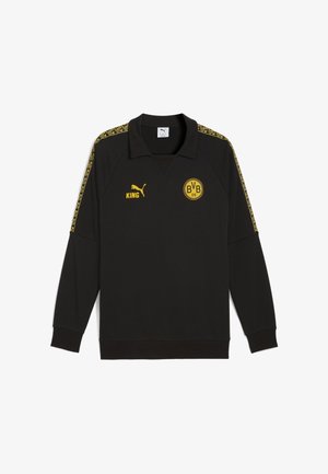 Melna garām piedurknēm pelēka krekla ar apkakles kaklu, dzelteniem akcentiem, BVB logotipu un Puma zīmolu. Iekļauj izstrādātas sānu svītras.